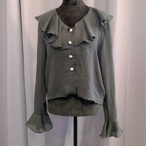 Sexy sheer black polka dot blouse it’s bell sleeves and pearl buttons.